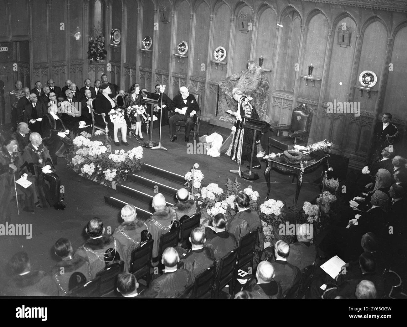 La statua in bronzo di Sir Winston per la City di Londra che verrà inaugurata alla Guildhall di Londra dal Lord Mayor di Londra è una statua di Sir Winston Churchill a grandezza naturale . La statua fu commissionata dalla corparazione di Londra per la nuova sala del consiglio ed è opera dello scultore Oscar Nemon . Sir Winston sarà presente all'inaugurazione Sir Winston ha tenuto un discorso nel quale ha osservato "almeno questo mi somiglia", mentre il Lord sindaco, Sir Seymour Howard, esegue la cerimonia di inaugurazione, Sir Winston siede accanto all'immagine seduta di himsel 21 giugno 1955 Foto Stock