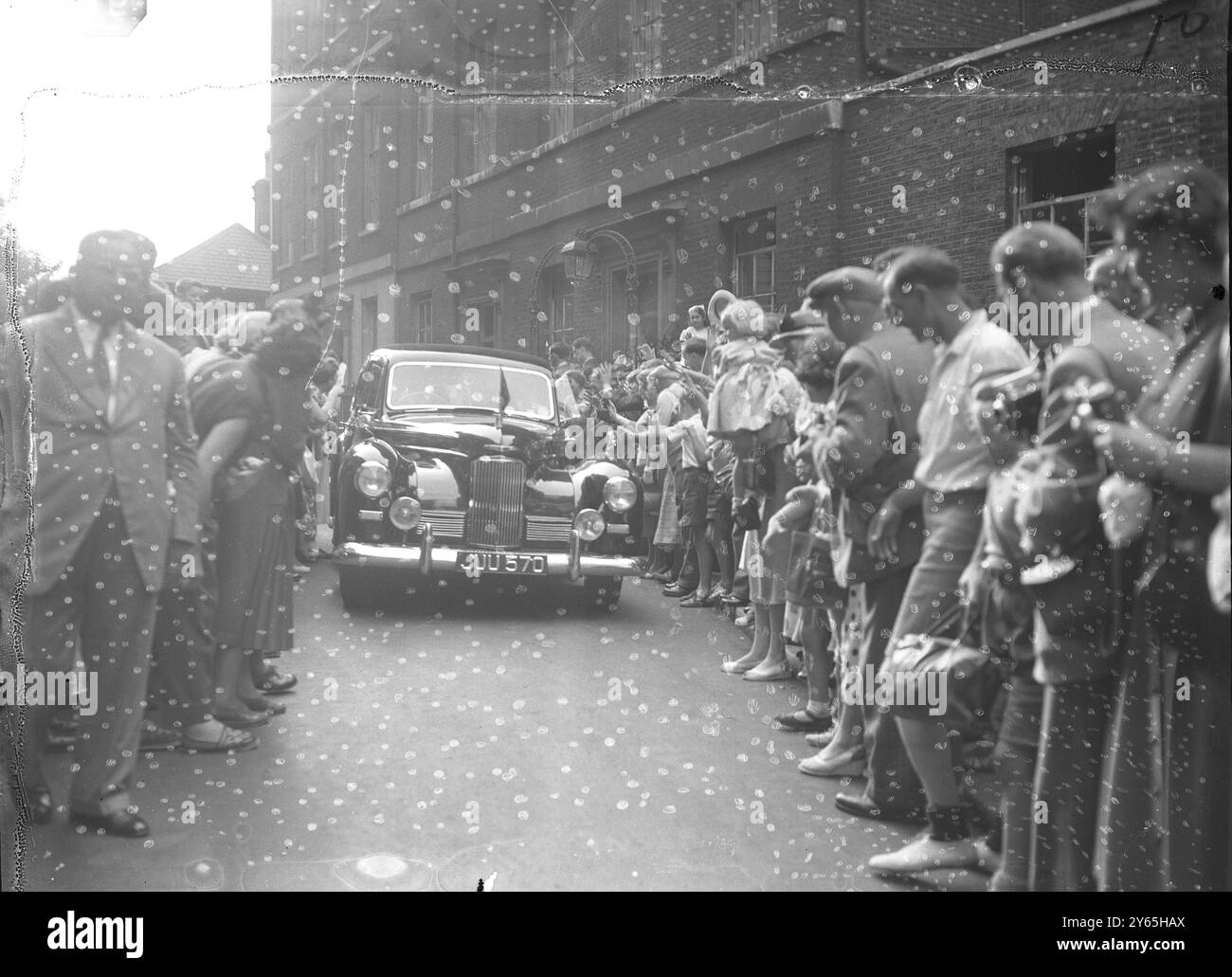 Hanno applaudito Churchill la folla di Downing Street torna indietro per far posto alla macchina del primo Ministro, Sir Winston Churchill, mentre partiva per la sua casa di campagna, Chartwell, Kent, dopo aver chiamato al n.10 . Churchill visitò Downing Street dopo aver guidato da Chequers , la residenza ufficiale di campagna dei primi ministri britannici . 12 agosto 1953 Foto Stock