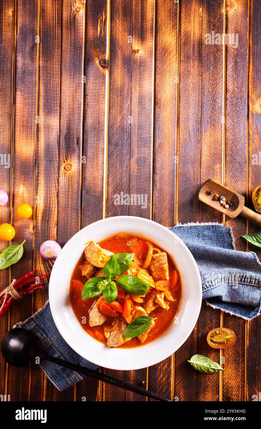 carne cotta al forno con salsa di pomodoro nel recipiente su un tavolo Foto Stock