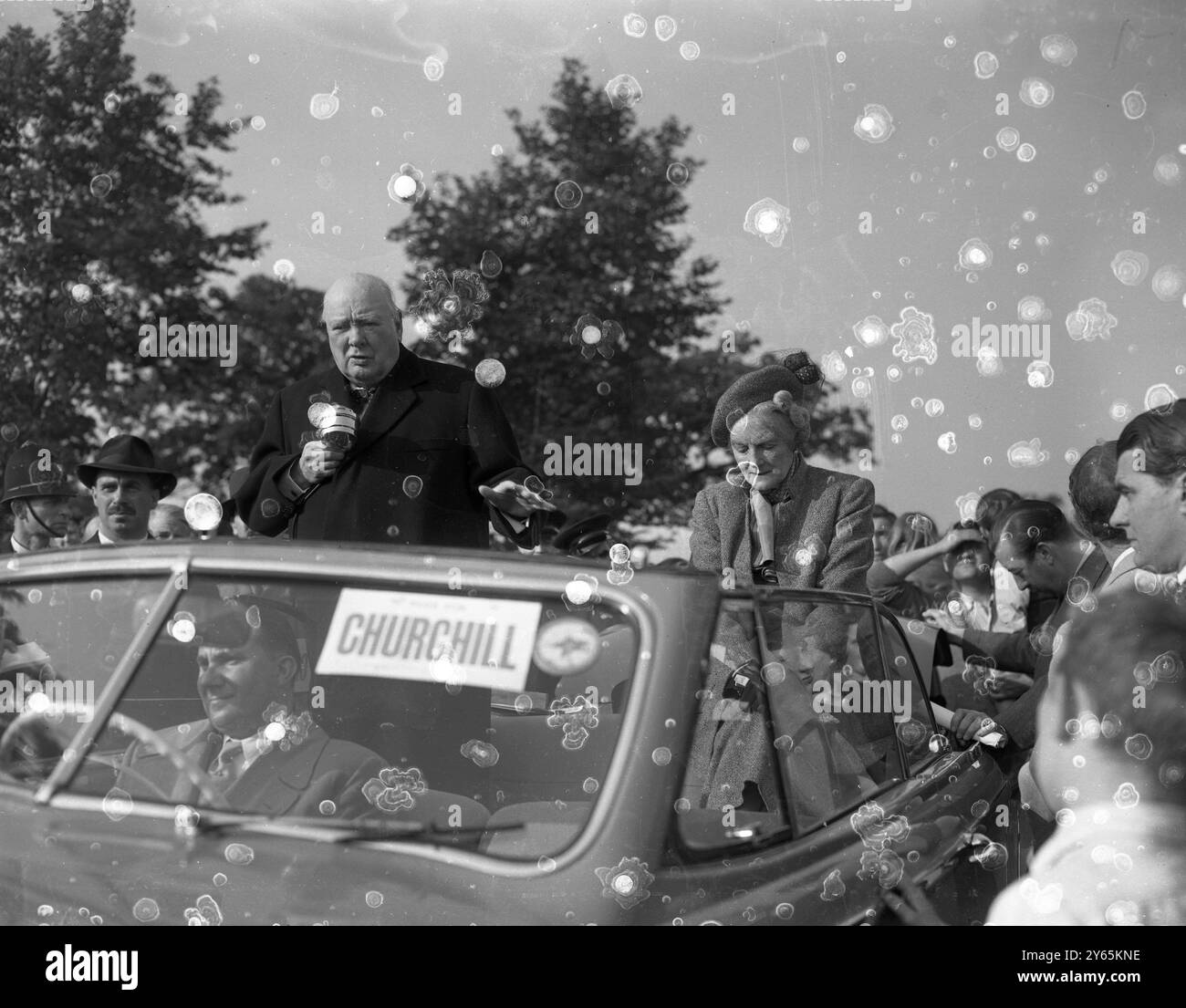 Churchill le campagne candidate . Winston Churchill con la signora Churchill al suo fianco , parlando dalla sua auto durante un tour a Woodford , Essex , il suo collegio elettorale alle elezioni generali . 6 ottobre 1951 Foto Stock