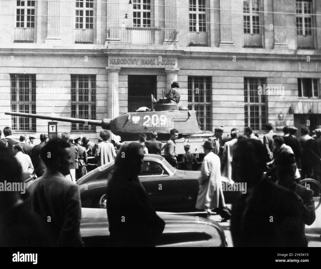 Poznan, Polonia, Una folla malata guarda come un carro armato russo T34 si trova di fronte ad un edificio della banca Poznan. La rivolta ha finora causato la morte di circa 70 persone, mentre altre 300 sono rimaste ferite. Si dice che trecento persone siano in arresto in quanto presunti leader della polizia segreta di Poznan sono stati saccheggiati e una prigione è stata presa d'assalto e licenziata nel giugno 1956. Foto Stock