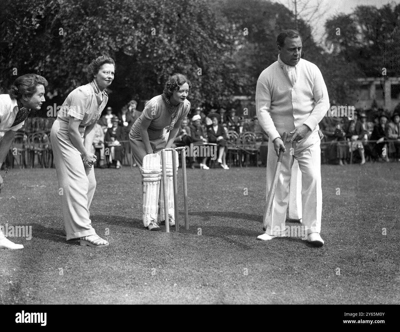 J B Priestley in partita di cricket. Una partita di cricket tra autori e attrici è stata una caratteristica speciale del Gala Garden Party tenutosi a Caen Wood Towers , Hampstead Lane , Highgate in aiuto della Sherborne Nursery School e dei gruppi Nord e Sud-Ovest della St Pancras House Improvement Society . J B sacerdotale capitanò gli autori e Beatrice Lillie , le attrici . Spettacoli fotografici: J B Priestley che combatte con Ursula Jeans come guardiano del wicket . 12 luglio 1938 Foto Stock