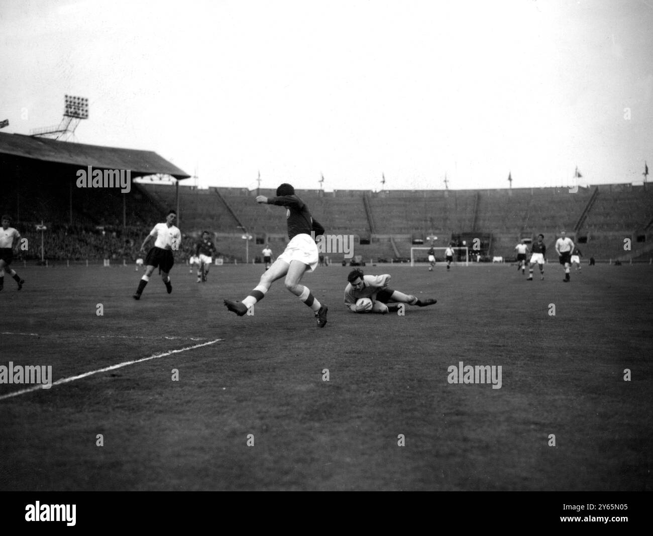 Il portiere della Gran Bretagna M Pinner cade sul pallone mentre salva da G Dimitrov , l'interno della Bulgaria nella partita di qualificazione ai Giochi Olimpici all'Empire Stadium di Wembley. I dilettanti britannici , a partire da un deficit di due gol - hanno perso contro la Bulgaria a Sofia - hanno combattuto i visitatori per un pareggio del 3-3. Per andare avanti a Melbourne , hanno dovuto vincere con un margine di tre gol . 13 maggio 1956 Foto Stock