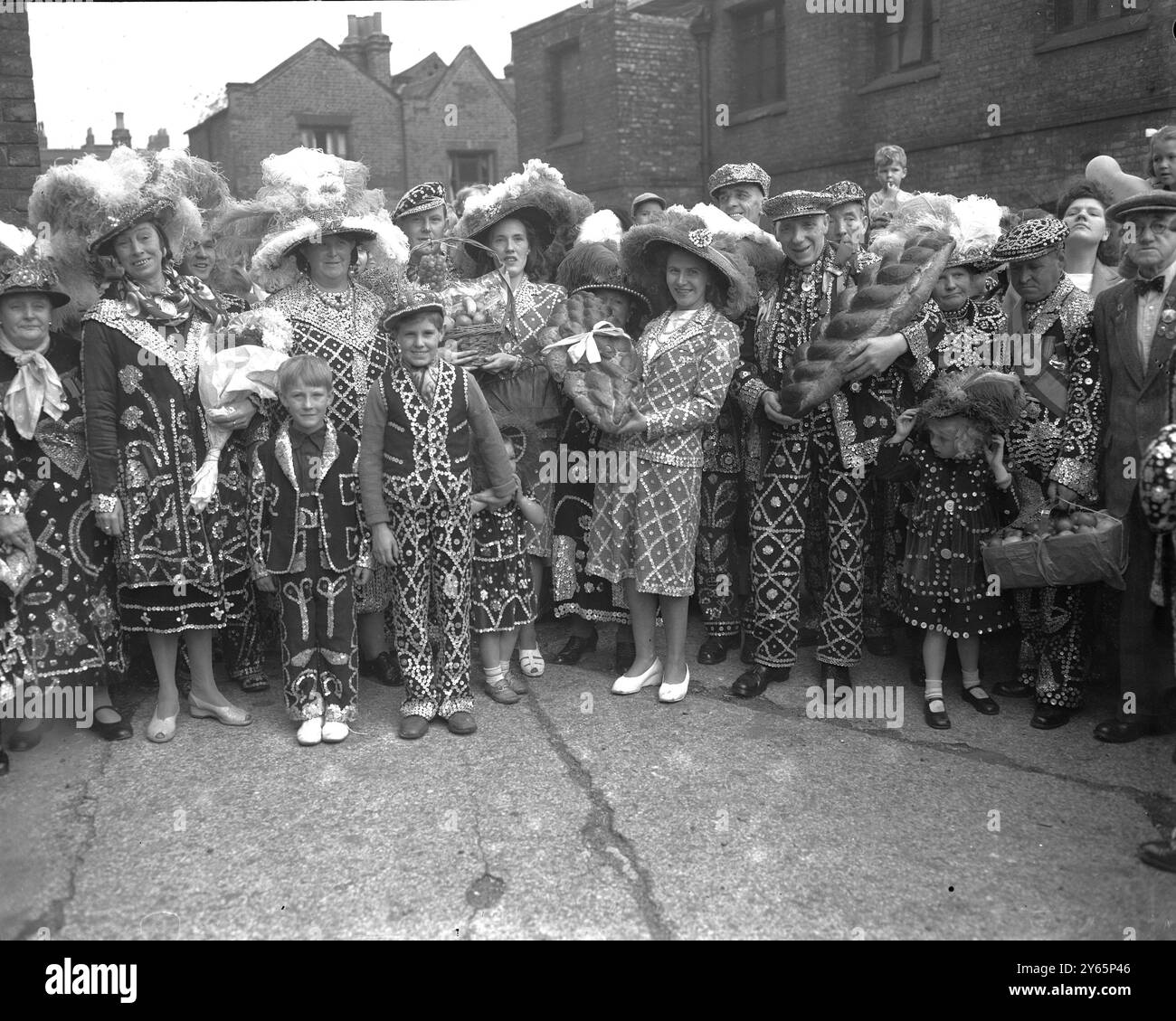 La festa annuale del raccolto dei mongoli coster Mongers si svolse presso la " Cattedrale di Costers " , la chiesa di Santa Maria Magdelena , Southwark . I costi andarono in chiesa vestiti con le loro perle, condotti alla chiesa da Jim Duckworth, 77 anni, "Re Pearly" di Walworth. Qui , alcuni dei costi che arrivano per la festa del raccolto con i loro doni . - 9 ottobre 1949 Foto Stock