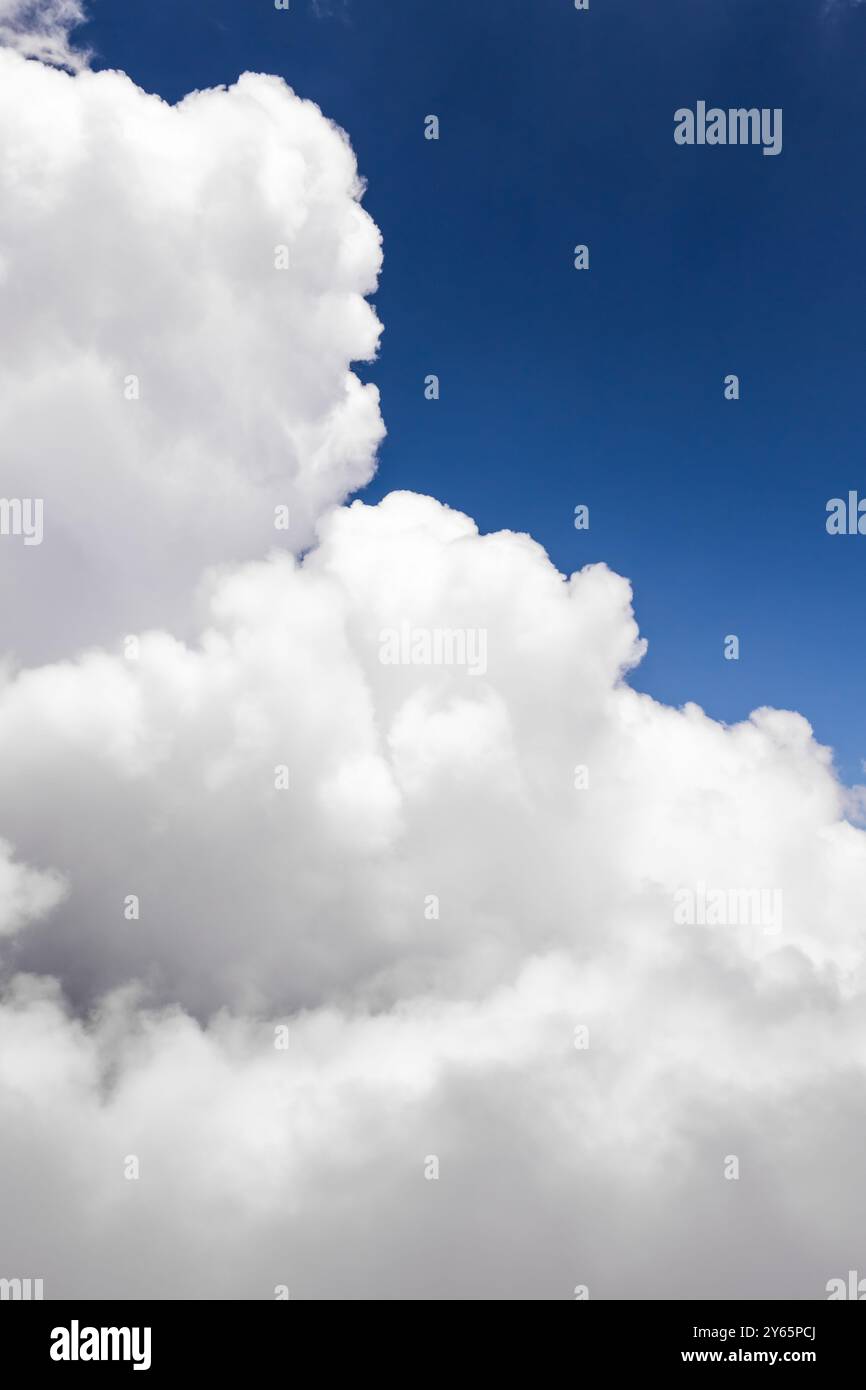 Un'immagine mozzafiato che mostra ampie nuvole bianche che si infrangono su un cielo azzurro, perfetta per evocare un senso di apertura e ispirazione Foto Stock