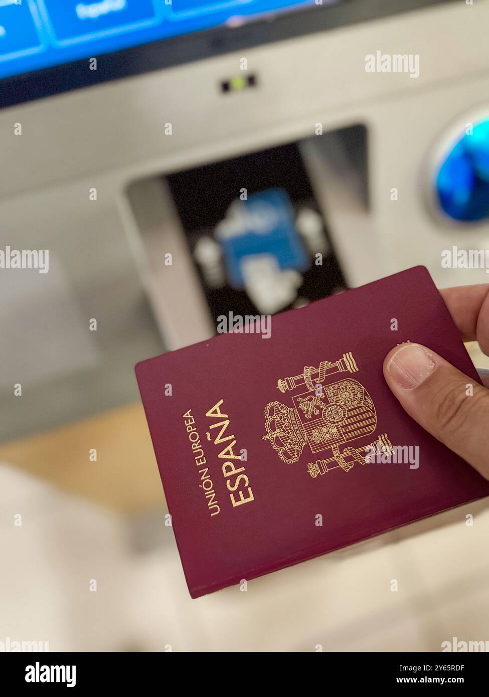 Mano corta e irriconoscibile, con passaporto spagnolo al gate d'imbarco, che rappresenta il viaggio internazionale e la verifica dell'identità prima di un flig Foto Stock