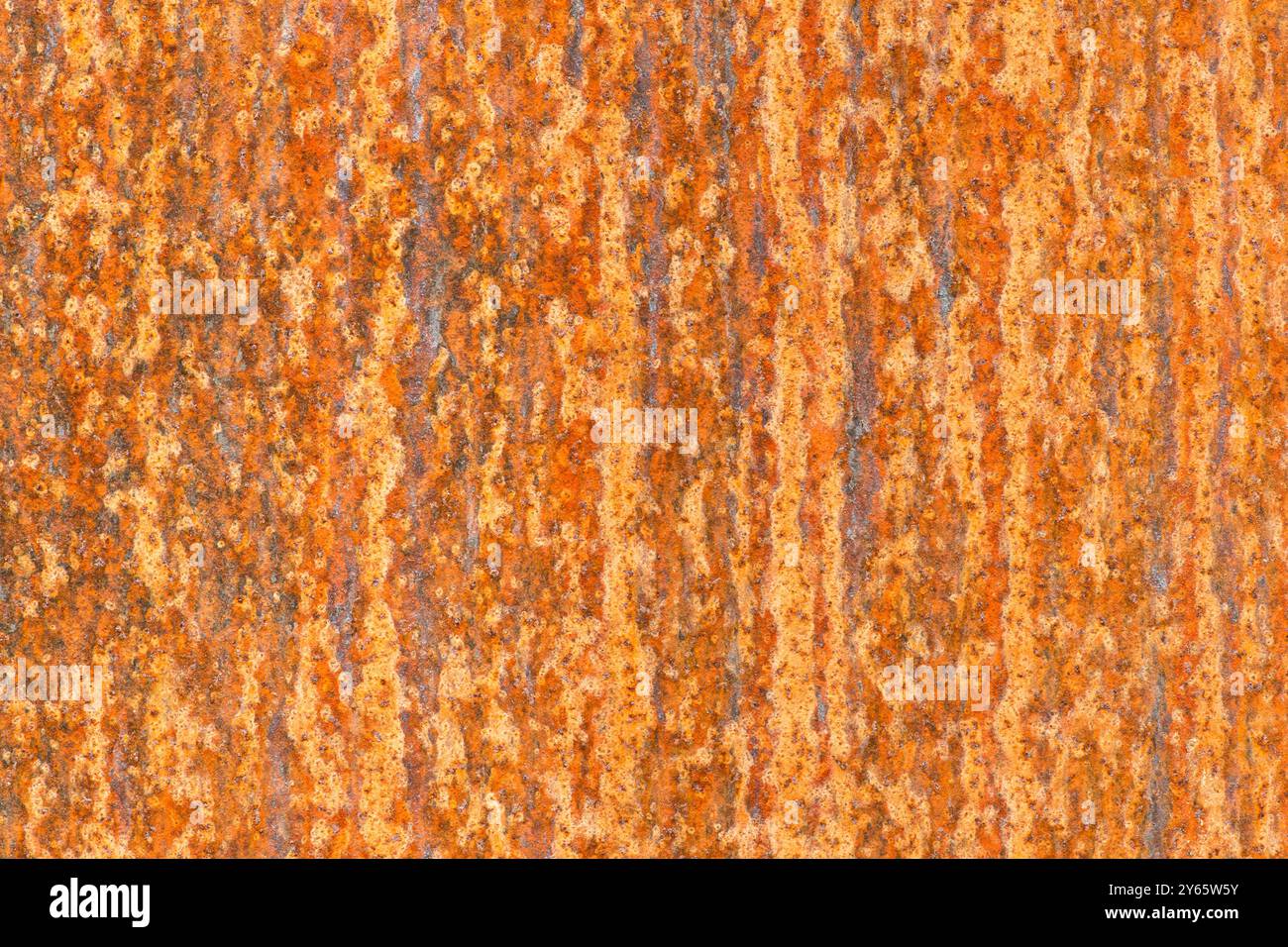 Immagine ad alta risoluzione che cattura gli schemi dettagliati di corrosione e decadimento su una superficie metallica arrugginita, con un mix di tonalità arancio e marrone. Foto Stock