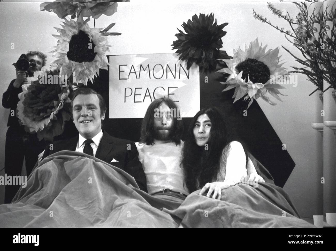 La competizione televisiva Eamonn Andrews si siede in un letto con John Lennon e Yoko Ono durante il programma televisivo Thames "Today". La coppia ha intervistato Eamonn sul programma . John e Yoko sono tornati a Londra da Amsterdam , dove sono stati a letto per una settimana all'Hilton Hotel , come protesta contro la violenza mondiale . Oggi , hanno annunciato che avrebbero inviato ai leader mondiali una ghianda ciascuno per piantare per la pace il 1 aprile 1969 Foto Stock