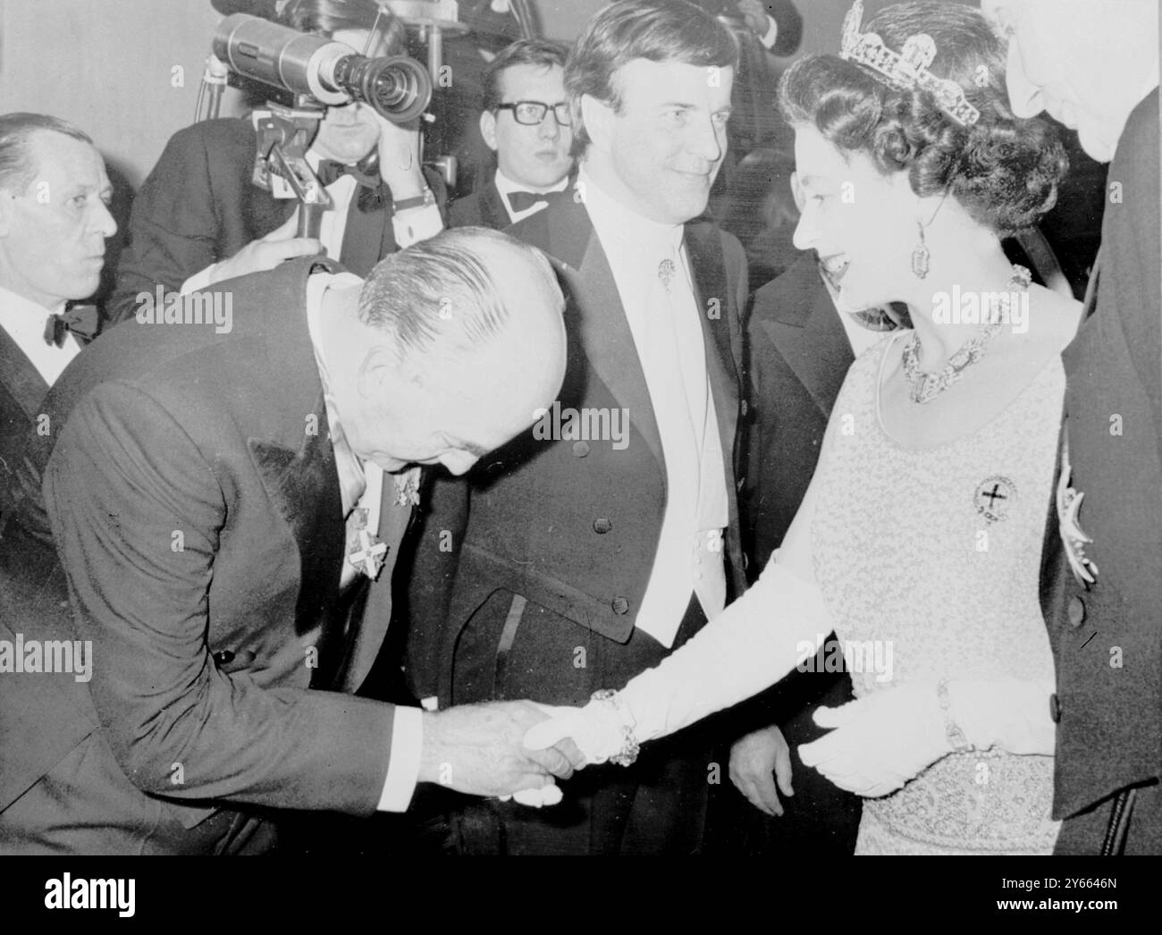 Sua Maestà la Regina Elisabetta II stringe la mano al dottor Eitel Monaco, presidente dell'industria cinematografica italiana, prima della rappresentazione del 1968 di Romeo e Giulietta. Al centro c'è il produttore italiano Franco Zeffirelli. 5 marzo 1968 Foto Stock