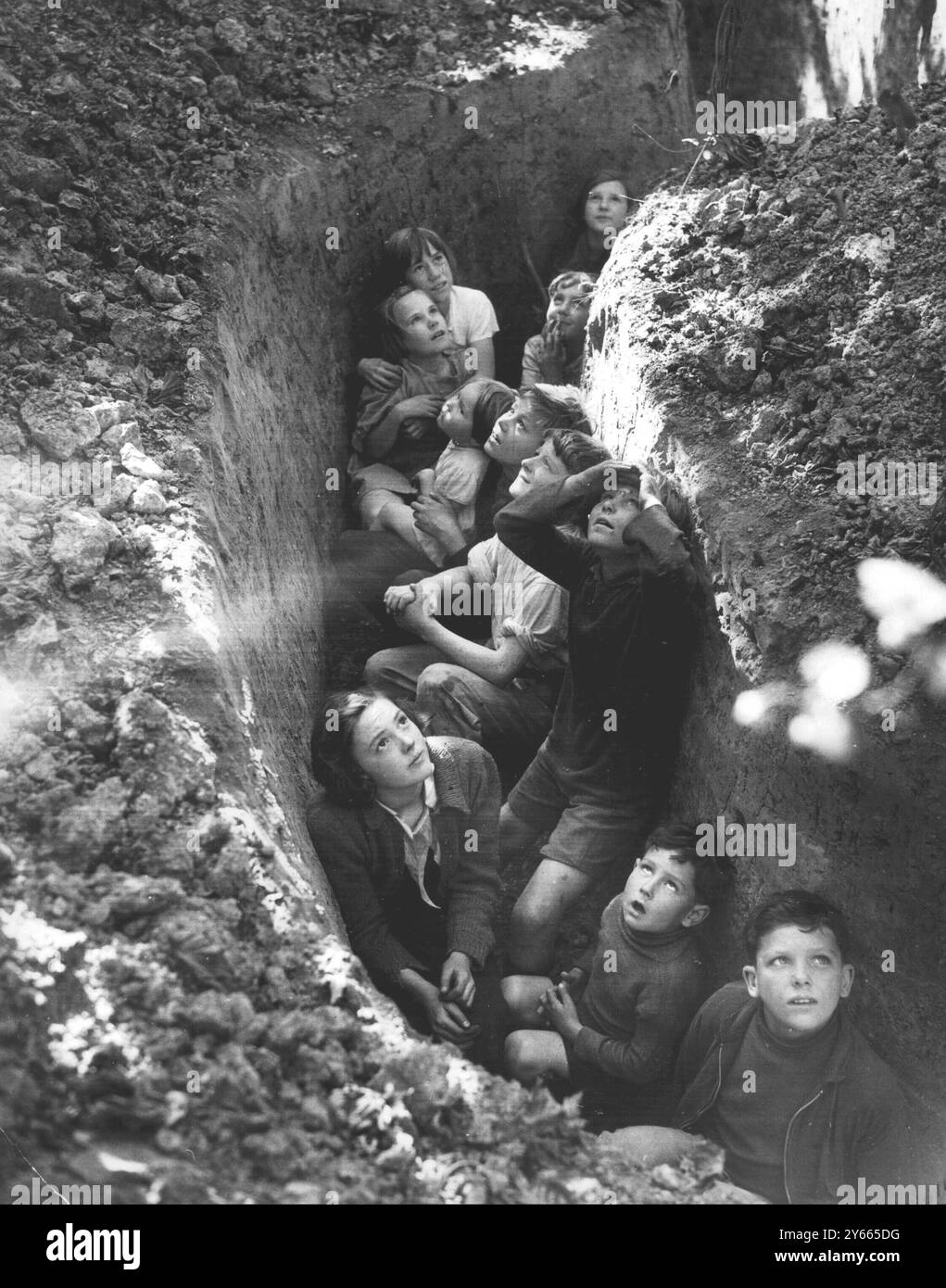 Una delle più famose fotografie della seconda guerra mondiale. Trincee scavate nel Kentish Hopfields in modo che i raccoglitori potessero prendere copertura durante la Battaglia d'Inghilterra. I bambini dell'East End usano le trincee per guardare gli aerei in azione. 1940 Foto Stock