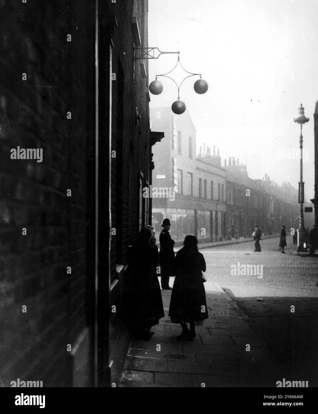 Le donne di Londra del Regno Unito aspettano fuori da un pedone per aprirla il lunedì mattina nell'East End. Un sondaggio del tempo ha scoperto che una famiglia su tre avrebbe usato il pewnbroker. Circa 1930 foto di John Topham Foto Stock