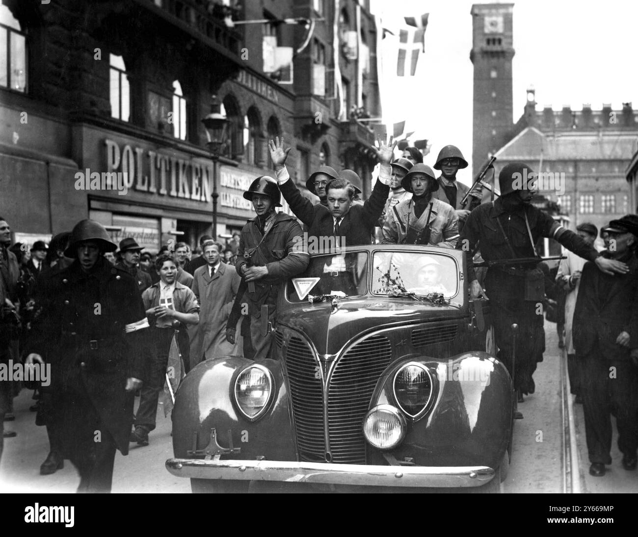 Il traditore viene scoperto, con le braccia sollevate sopra la testa, viene guidato per le strade di Copenaghen per essere processato come criminale di guerra - 9 maggio 1945 Foto Stock