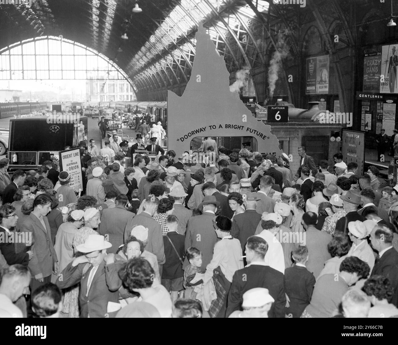 I britannici sono Un "regalo di compleanno"! La scena affollata di St Pancras, Londra, come gruppo di 437 inglesi partì per la prima tappa del loro viaggio a Brisbane, Australia. I migranti salperanno questo pomeriggio da Tilbury nell'Orion, che sta facendo un viaggio speciale a Brisbane per le celebrazioni del 100° compleanno dello stato del Queensland. Un cartello alla stazione li salutava con le parole "Doorway to a Bright Future" e le ragazze australiane gli davano dei bicchieri di succo di ananas del Queensland. 19 luglio 1959 Foto Stock