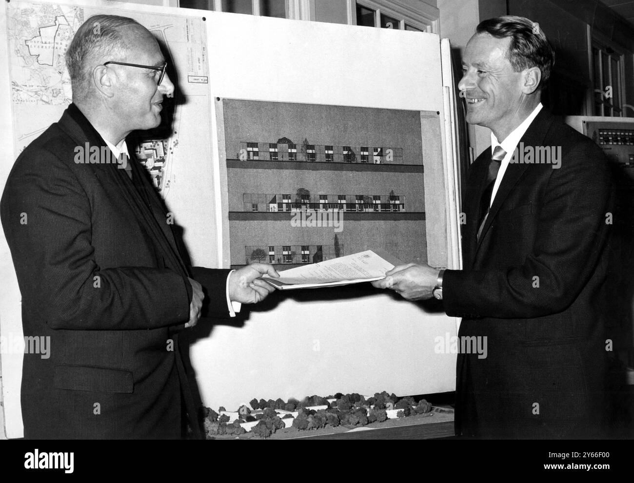 James Boyden (sinistra) Segretario parlamentare del Ministero degli edifici pubblici e dei lavori, consegna a Sir Maurice Laing (presidente della John Laing Construction Ltd) una lettera del ministro Charles Pannell, che accetta una gara per la costruzione di oltre 2000 case per soldati e marinai sposati utilizzando un metodo di costruzione industrializzato. 27 luglio 1965 Foto Stock