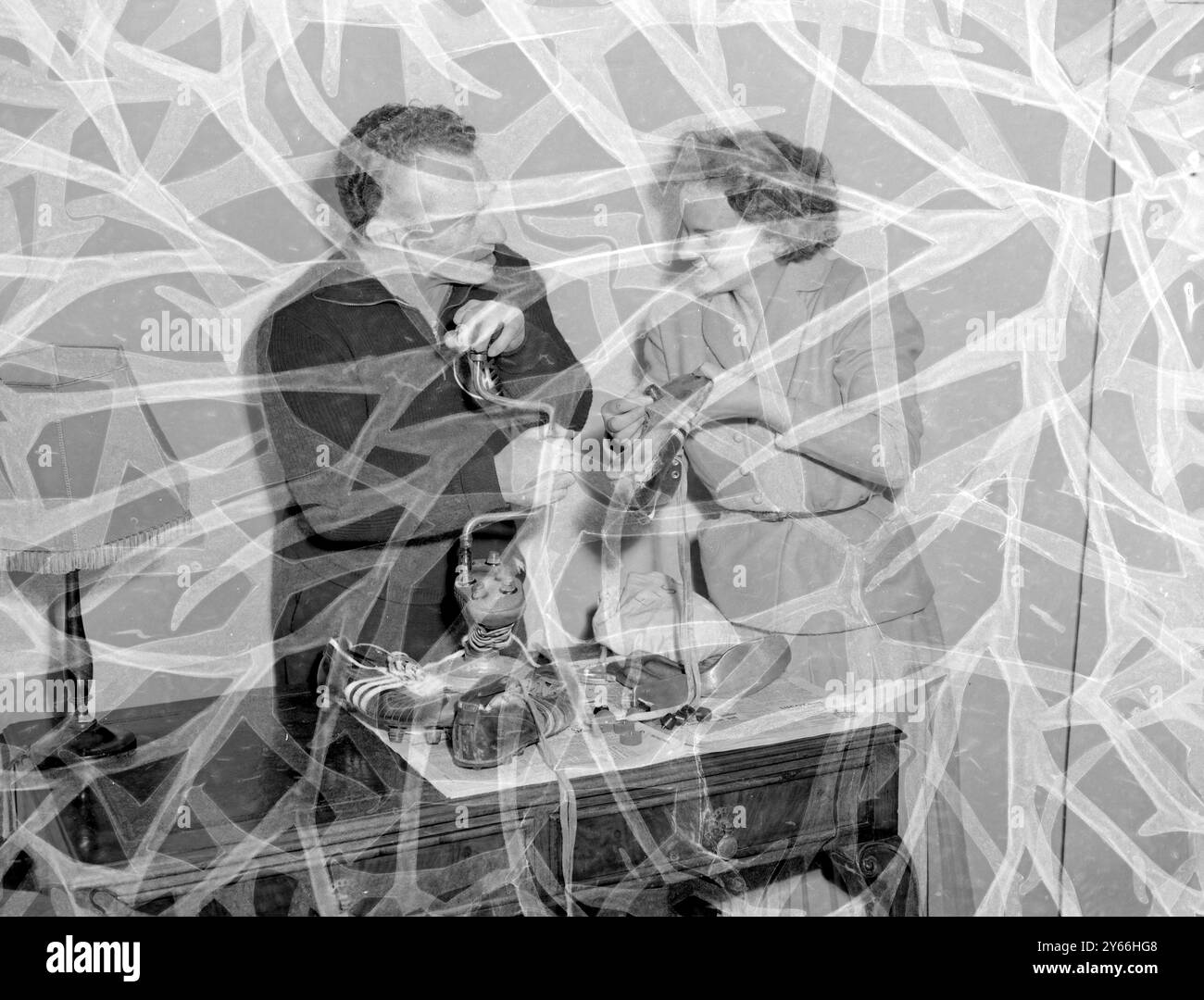 Ingeborg, figlia del calzolaio Adolf Dassler, guarda suo padre mettere dei borchie negli stivali che i membri della squadra tedesca di calcio indossano il 30 novembre 1954 Foto Stock