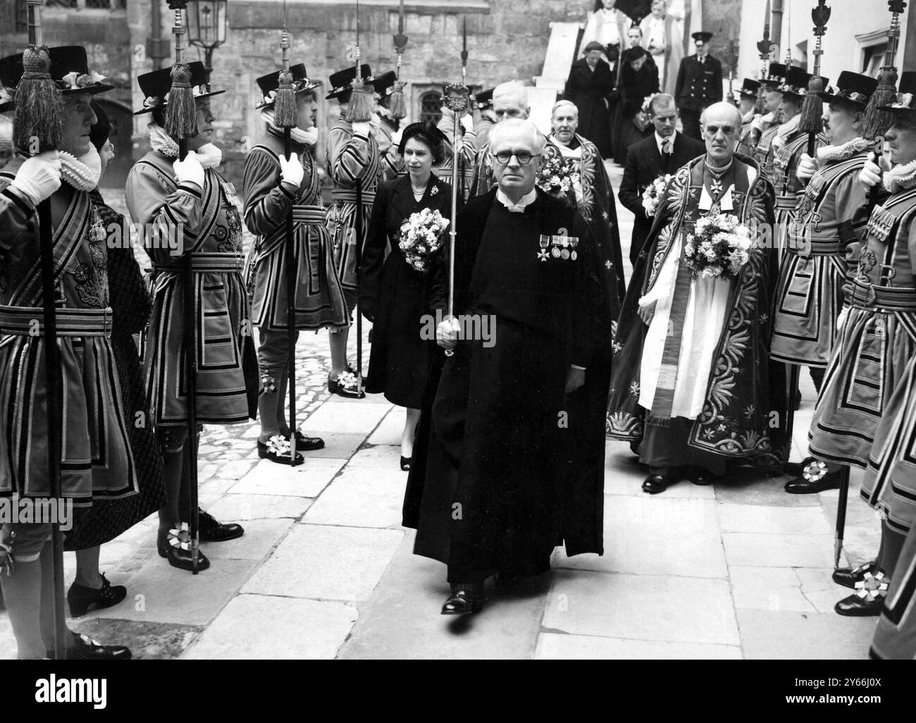 La regina (a sinistra) porta un bouquet; il dottor Don, decano dell'abbazia di Westminister (a destra); passando Yeomen della Guardia nelle loro uniformi tudor, dopo il servizio Maundy all'abbazia di Westminster. Questo fu il primo impegno pubblico della Queens dall'inizio del suo regno. - 10 aprile 1952. Foto Stock