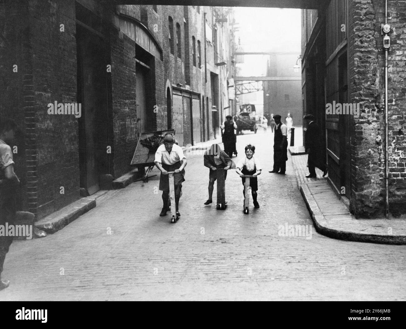 Ragazzi che giocano su scooter fatti in casa nei moli dell'East End di Londra. 1933 Foto Stock