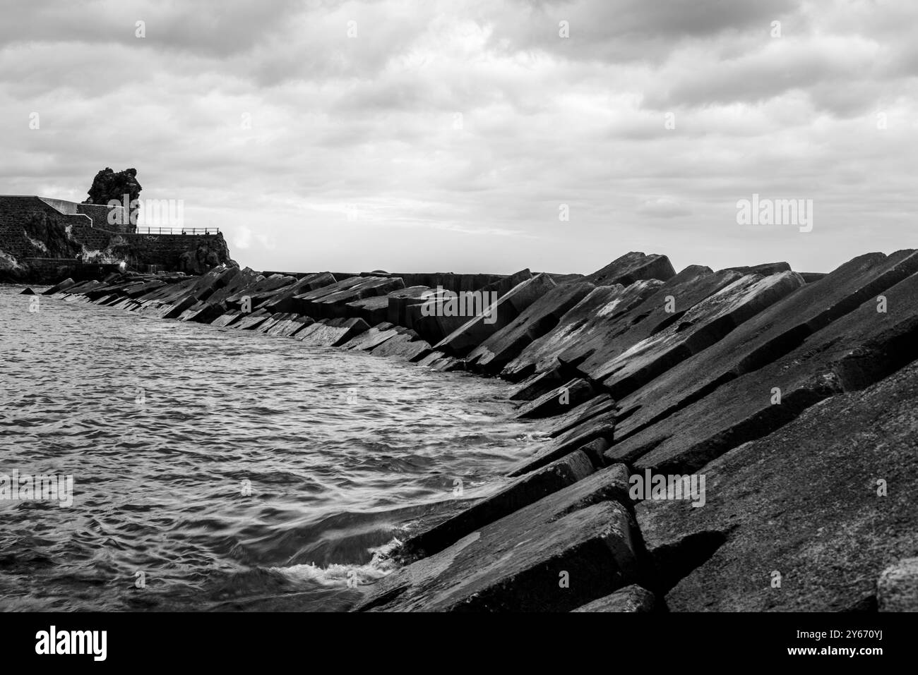 Massi di cemento armato confinano con la baia di Ponta do sol sull'oceano Atlantico a Madeira in Portogallo Foto Stock