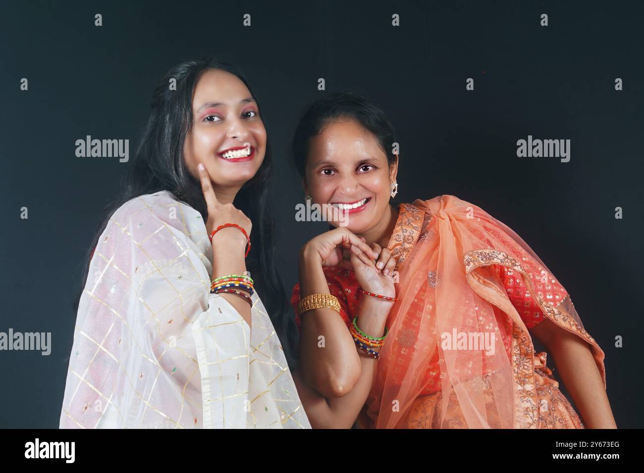 Questa foto colorata, che mostra una madre e una figlia che condividono un tenero abbraccio, racchiude perfettamente lo spirito festivo di Navratri. Esumano Foto Stock