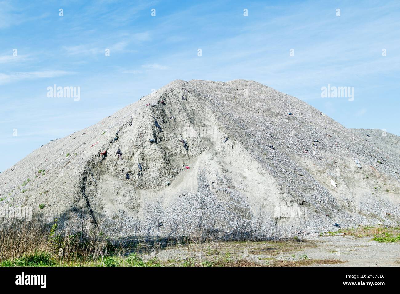 Un grande mucchio di macerie per la costruzione di strade. Pietra frantumata per calcestruzzo. Grandi pali di granito frantumato o ghiaia nell'industria del calcestruzzo Foto Stock