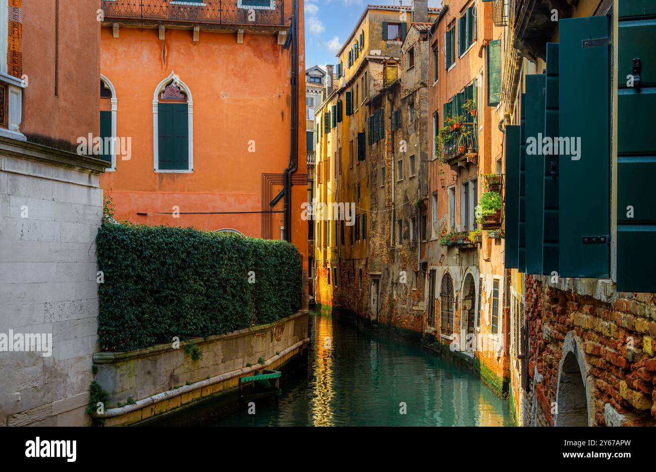 La luce del sole colpisce la fine di un edificio lungo il Rio Fuseri, un canale nel sestiere di San Marco di Venezia Foto Stock