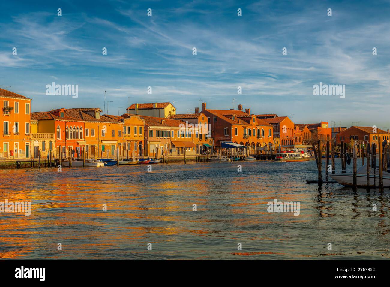 Il sole del tardo pomeriggio riflette i colori degli edifici lungo il Canal grande di Murano sull'isola di Murano vicino a Venezia Foto Stock