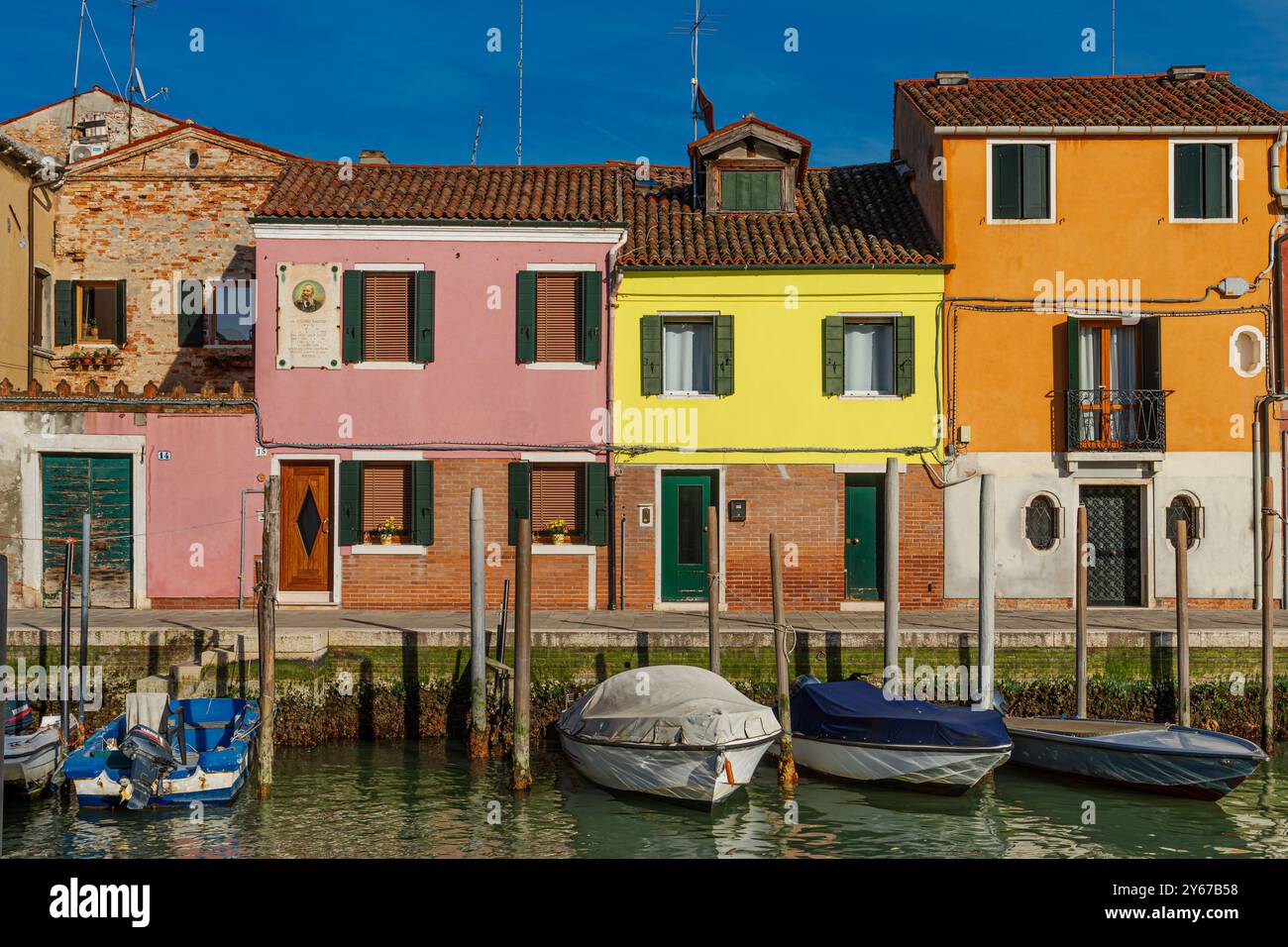 Piccole barche ormeggiate su un canale di fronte a case colorate lungo fondamenta Andrea Navagero sull'isola di Murano, vicino a Venezia Foto Stock