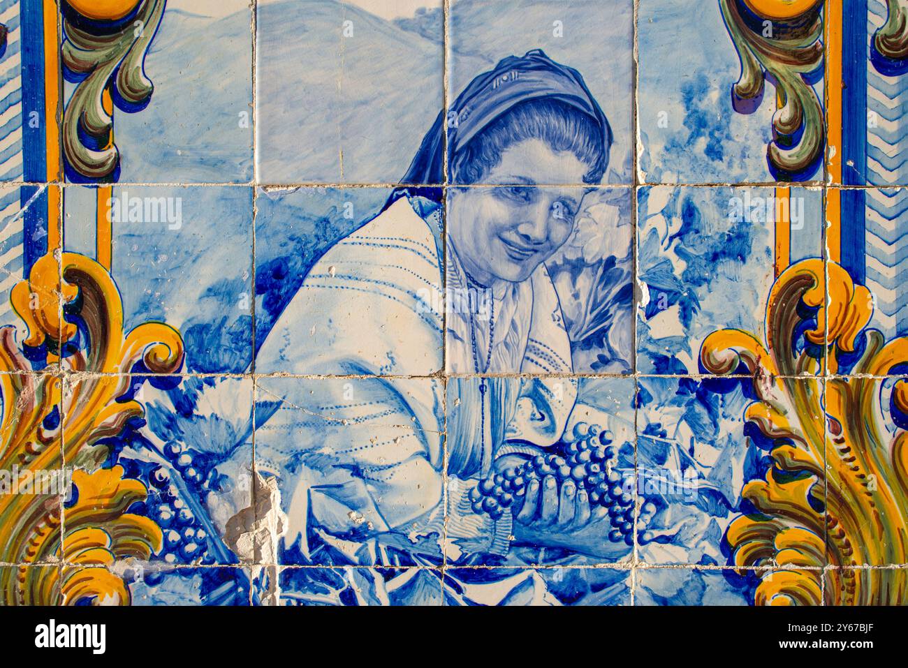 Primo piano di pannelli di piastrelle blu e bianche (azulejos), che mostrano la donna che raccoglie l'uva, la stazione ferroviaria esterna di Pinhao, Pinhao, Portogallo Foto Stock