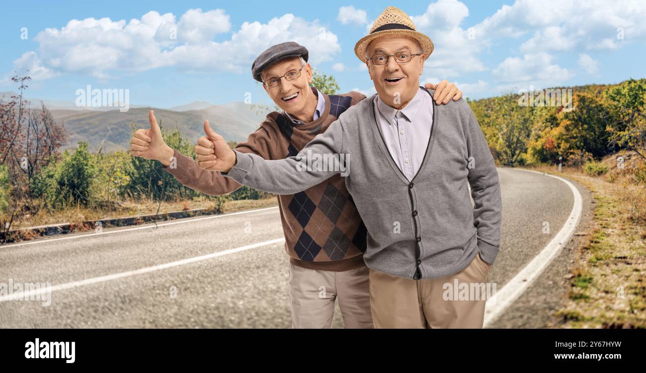 Uomini anziani che fanno autostop su una strada Foto Stock
