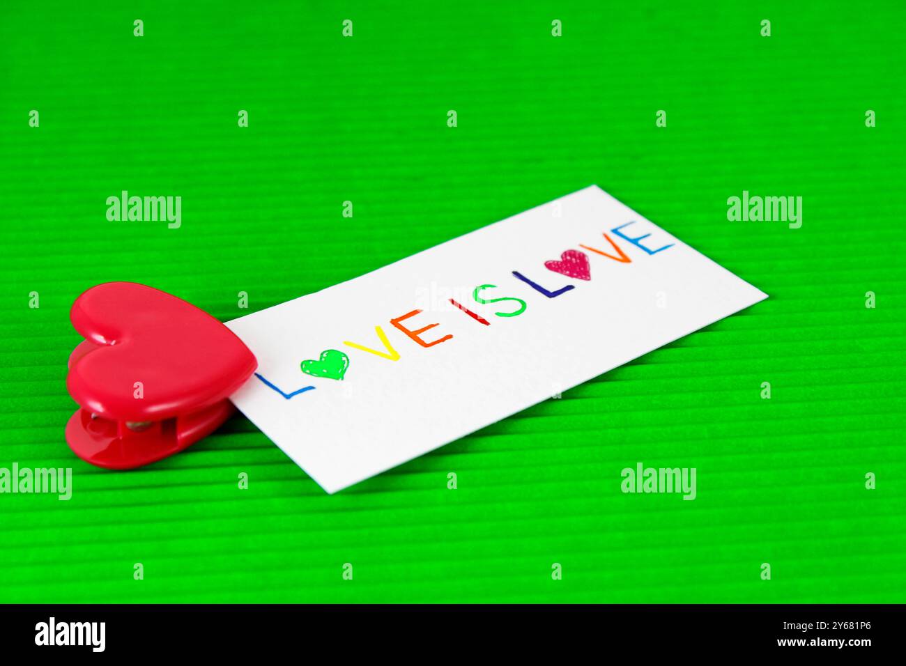 Clip a forma di cuore con una carta e la frase "amore è amore" Foto Stock