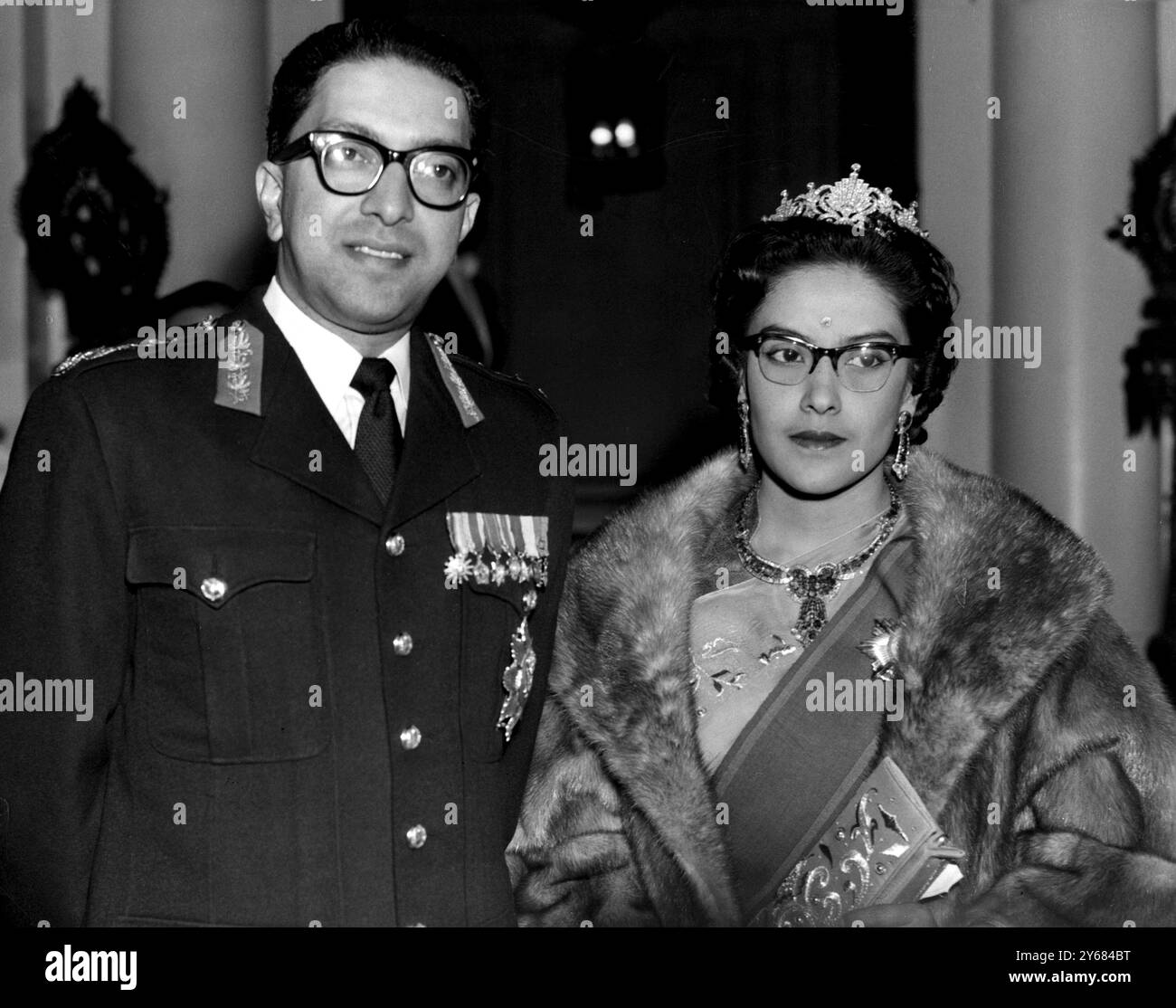 Londra: Il re Mahendra e la regina Ratna del Nepal arrivano all'ambasciata nepalese qui stasera per una cena da loro offerta per i membri della famiglia reale britannica. I 65 ospiti includevano la regina, il principe Filippo, la principessa Margherita e Anthony Armstong-Jones, il duca e la duchessa di Gloucester, la principessa reale, la duchessa di Kent, il duca di Kent e la principessa Alessandra. La regina Elisabetta indossava tulle di acquamarina, e il principe Filippo era vestito con cravatta e coda bianca. Una scia di rose rosse che corrono lungo i tavoli ha formato il motivo per la decorazione della tavola a cena. 18 ottobre 1960. Foto Stock