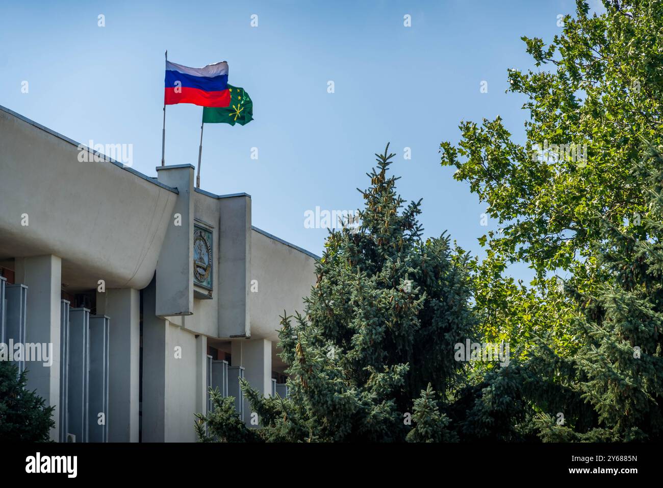 Le bandiere della Russia e della Repubblica di Adygea in cima all'edificio amministrativo della città di Maykop. Foto Stock