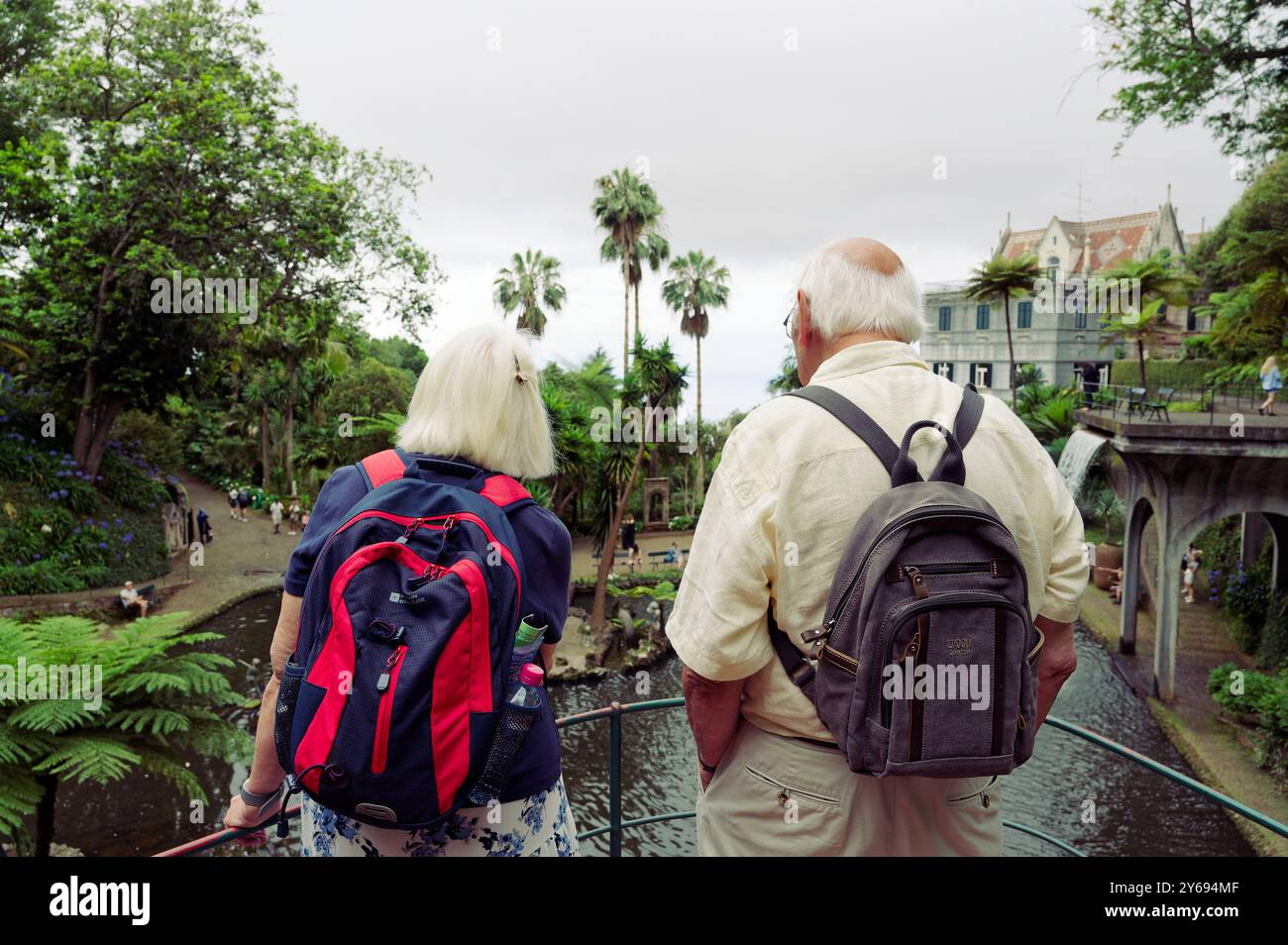 Coppie anziane che ammirano il paesaggio lussureggiante e il tranquillo laghetto dei giardini del palazzo monte Foto Stock