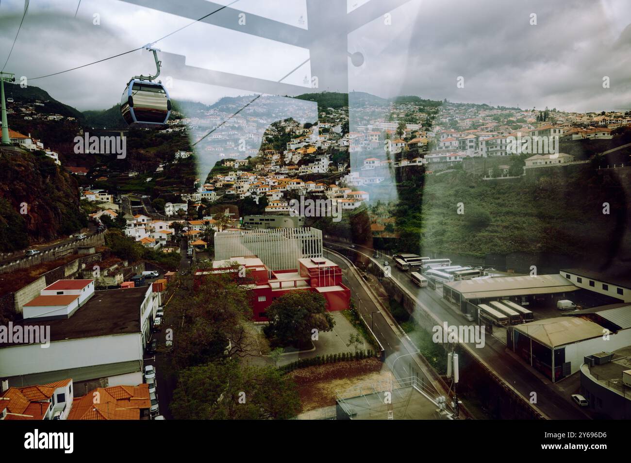 Vista dall'interno della funivia di funchal verso le colline ondulate e i tetti vivaci. Foto Stock