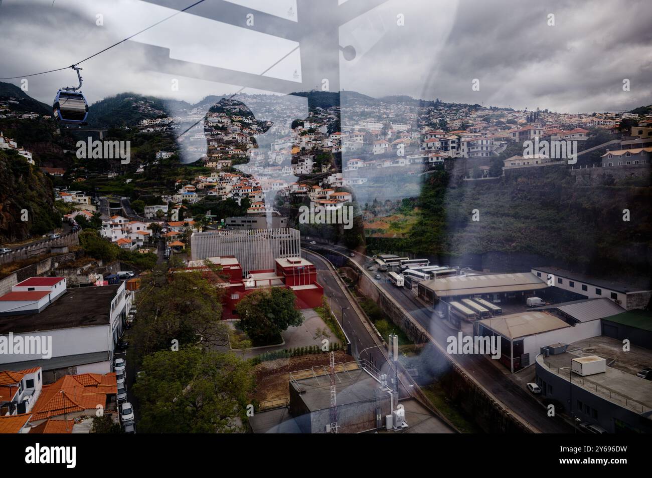 Vista dall'interno della funivia di funchal verso le colline ondulate e i tetti vivaci. Foto Stock