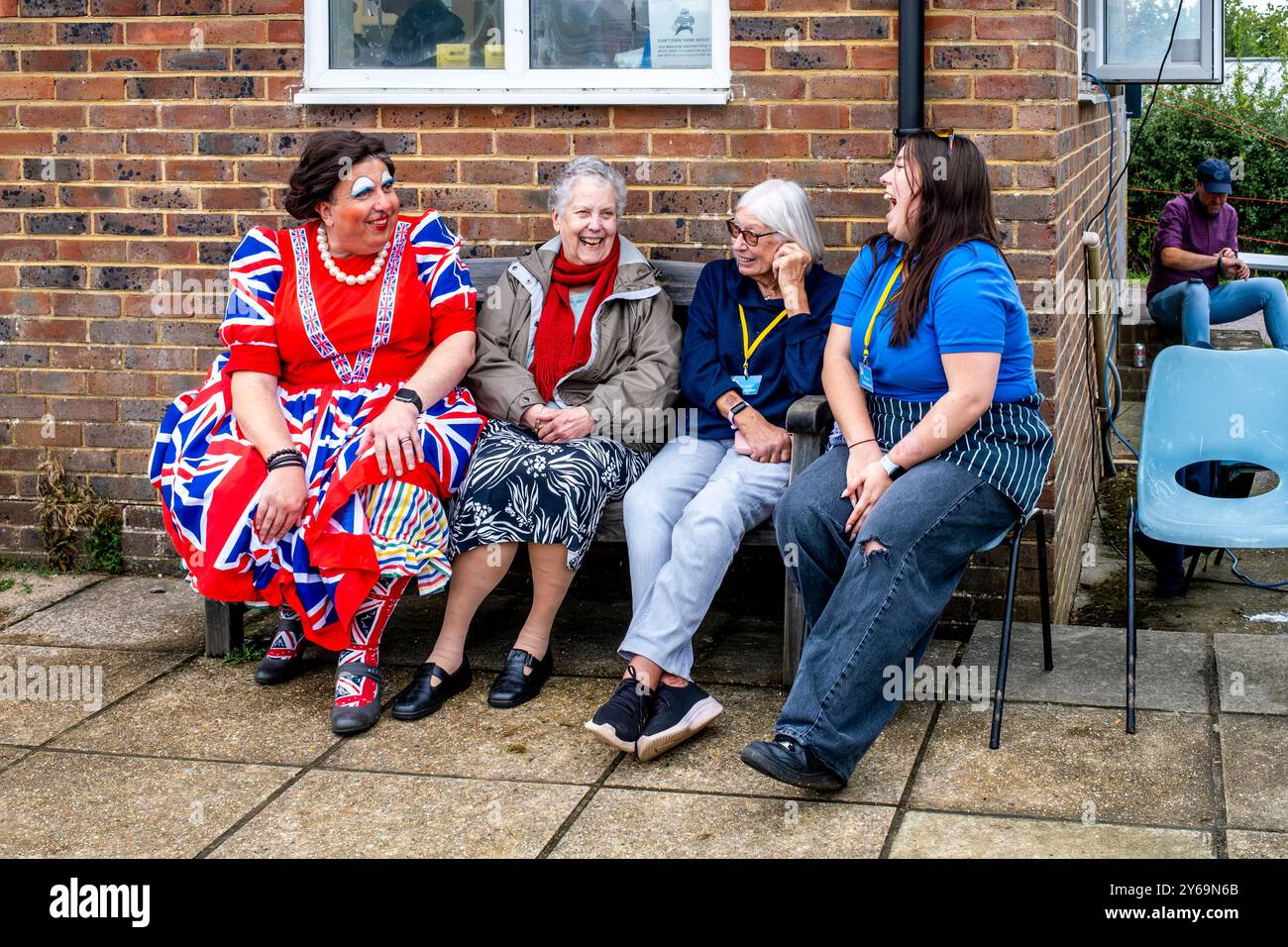 Un gruppo di persone siede a chiacchierare e ridere all'annuale Hartfield Village Fete, Hartfield, East Sussex, Regno Unito. Foto Stock