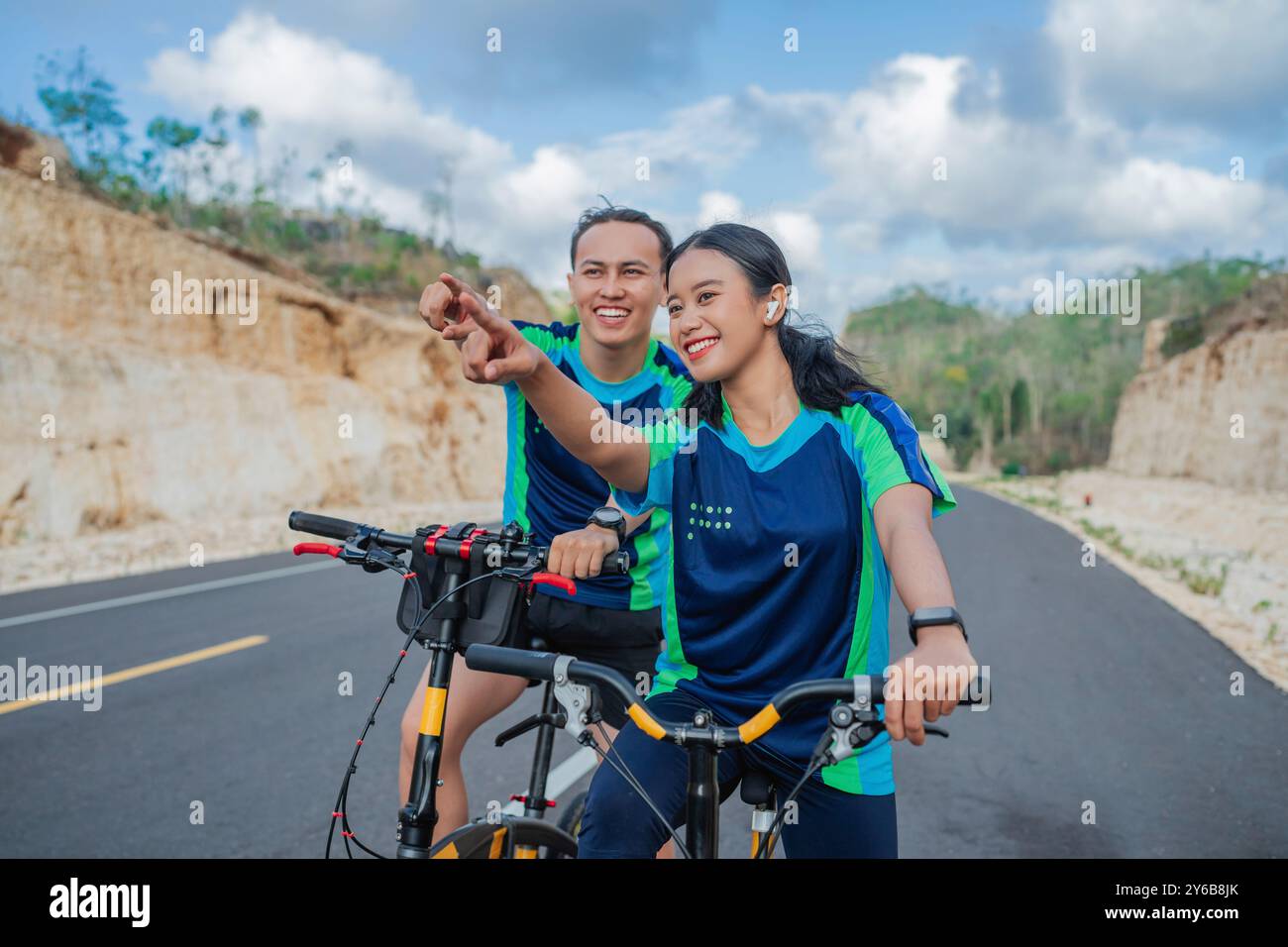 ciclista donna e uomo in bicicletta con gesto di puntamento Foto Stock