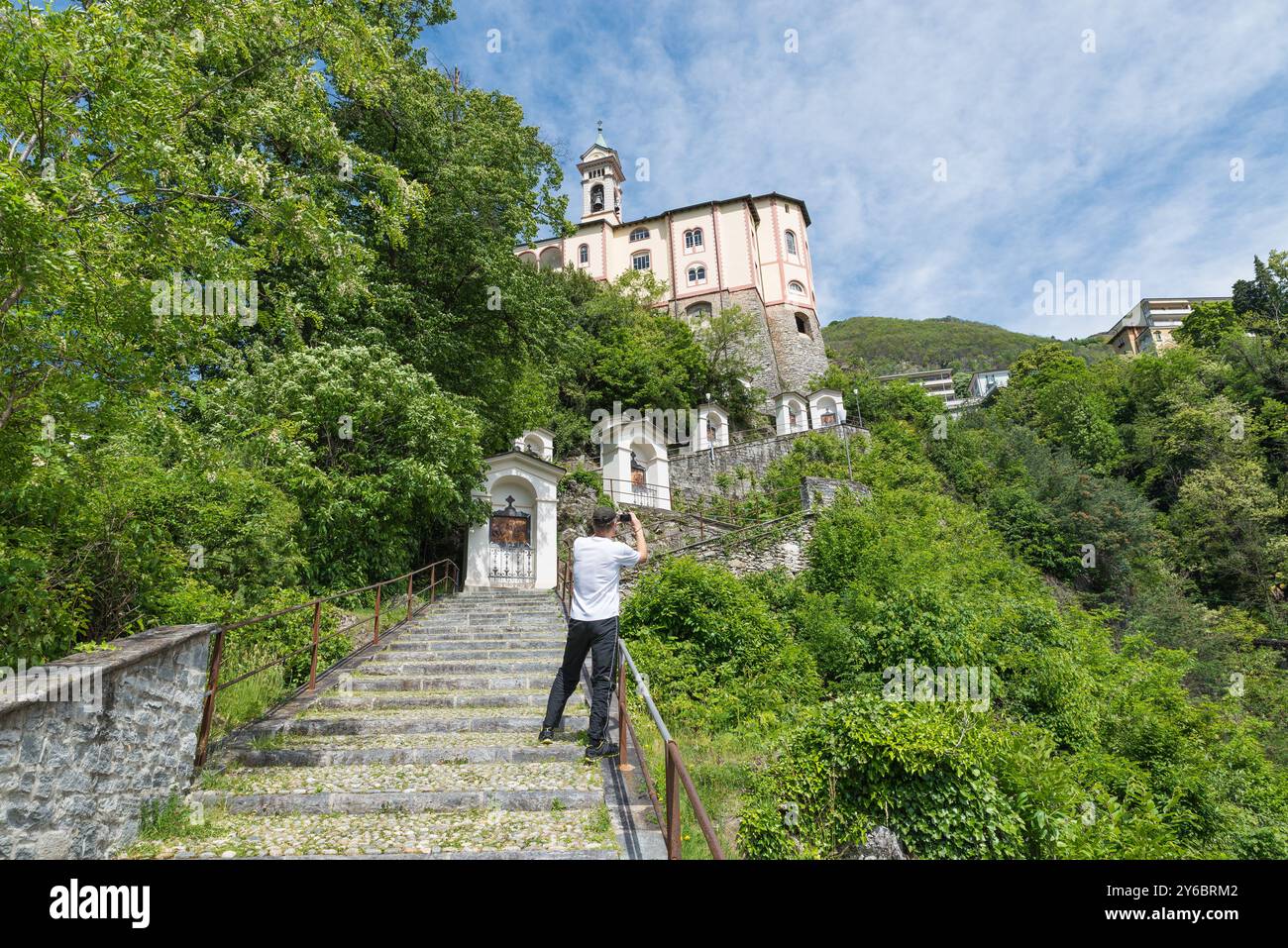 Turista a Locarno, Svizzera, sul Lago maggiore, fotografa il santuario della Madonna del Sasso a Orselina (Madonna della roccia - XV secolo) Foto Stock