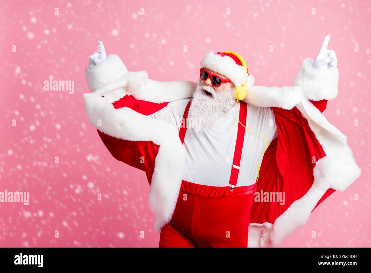 Foto pazzo funky fresca barba babbo natale godere di ascoltare stereo cuffie per musica volumetrica con un'atmosfera agile, x-mas christmas songs indossano per il nuovo anno pantaloni sospendenti Foto Stock