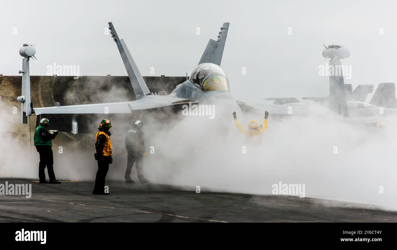 I marinai preparano un e/A-18G Growler, attaccato al Vikings of Electronic Attack Squadron (VAQ) 129, per il lancio sul ponte di volo dell'aircra di classe Nimitz Foto Stock