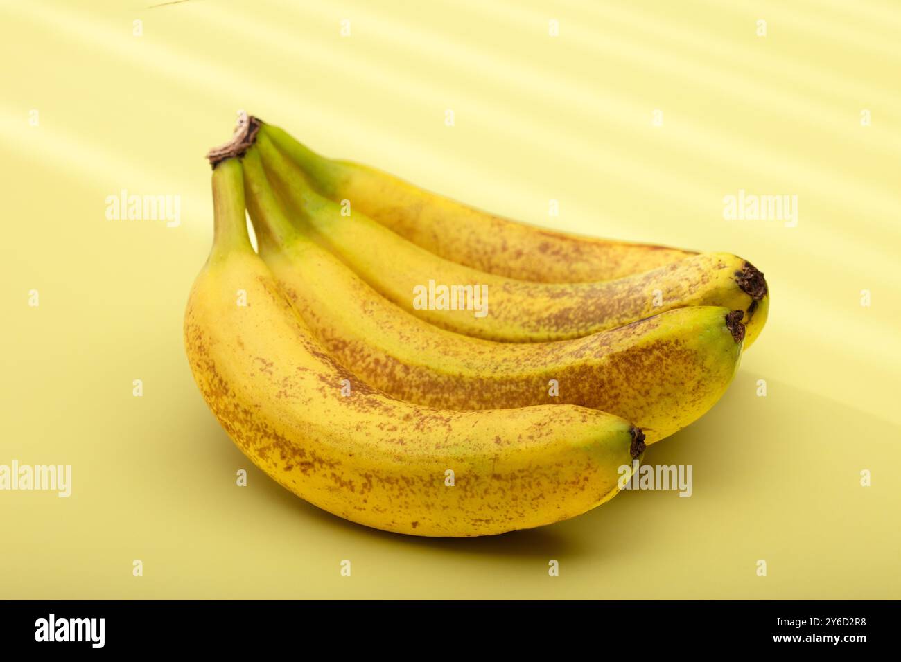 Banane gialle mature: Mucchio di frutta tropicale fresca su sfondo pallido - snack sano, cibo biologico naturale, ingrediente nutriente dieta Foto Stock