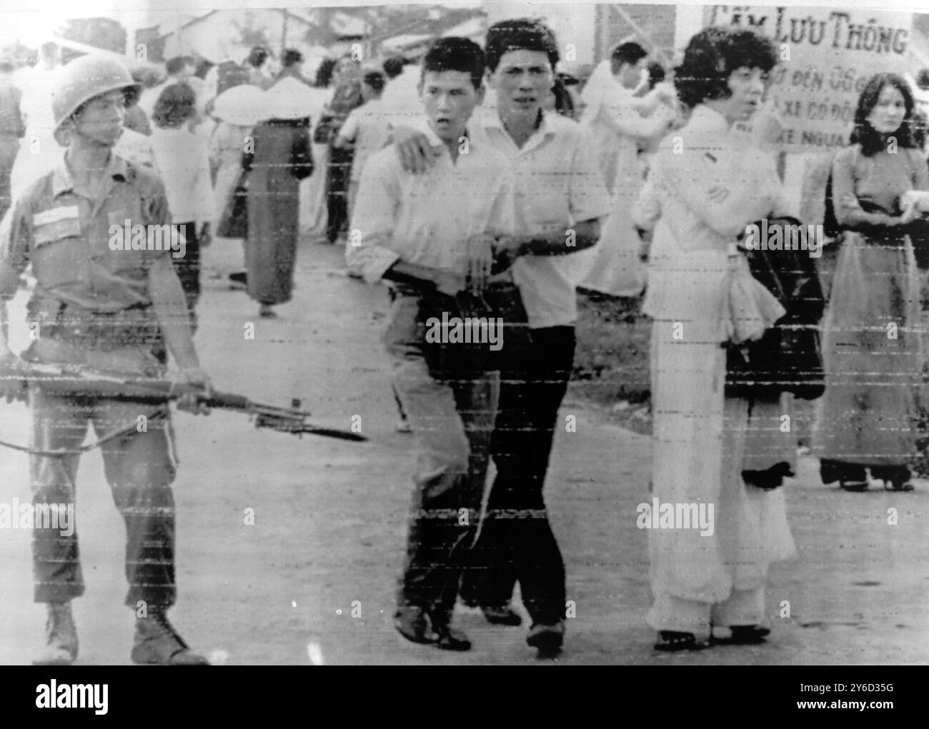 SOLDATO DI GUERRA DEL VIETNAM GUARDA COME STUDENTE RIUNITO CON I GENITORI A SAIGON ; 30 AGOSTO 1963 Foto Stock