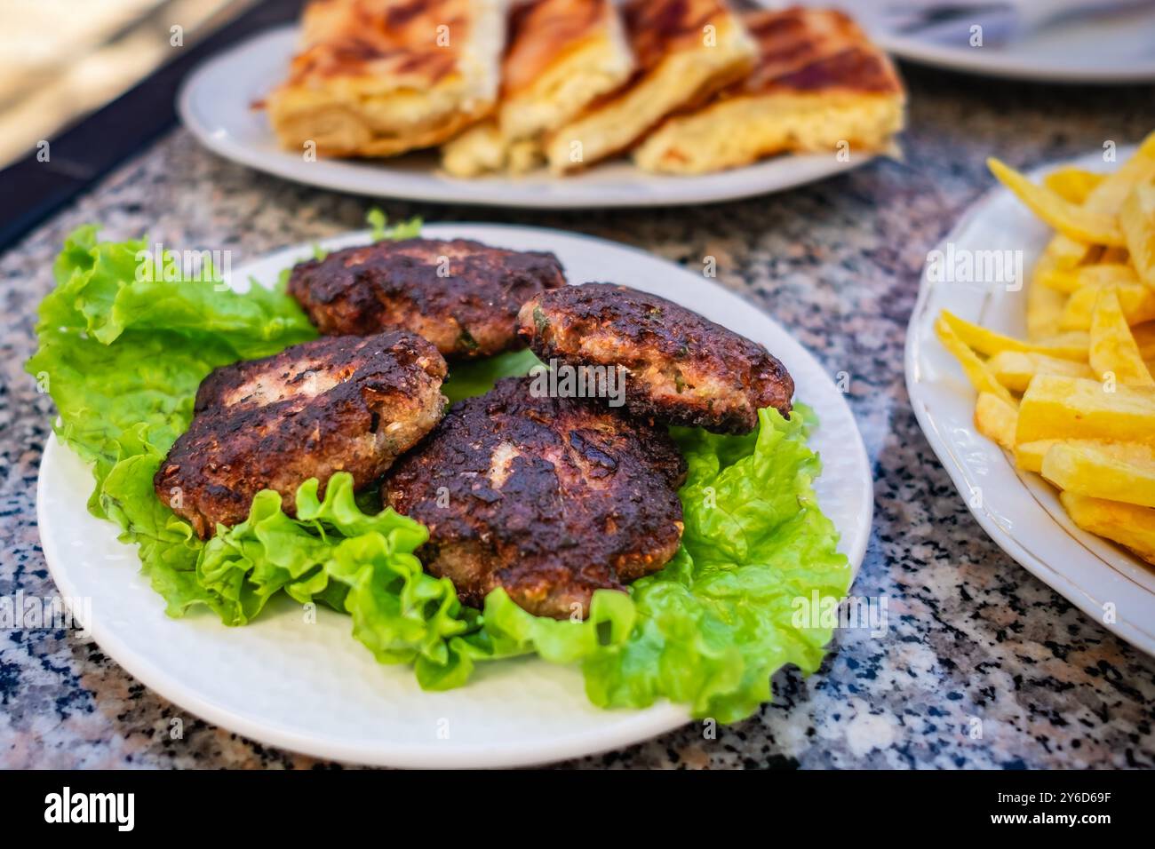 Cotoletta di hamburger alla griglia con foglie di insalata polpette di polpette secche e patatine fritte. Hamburger di cotolette fritte con lattuga su un piatto. Ko fatti in casa Foto Stock