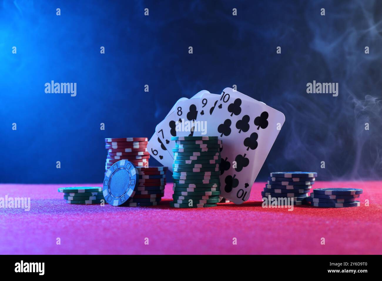 Fiche di poker e carte da gioco sul tavolo rosa Foto Stock