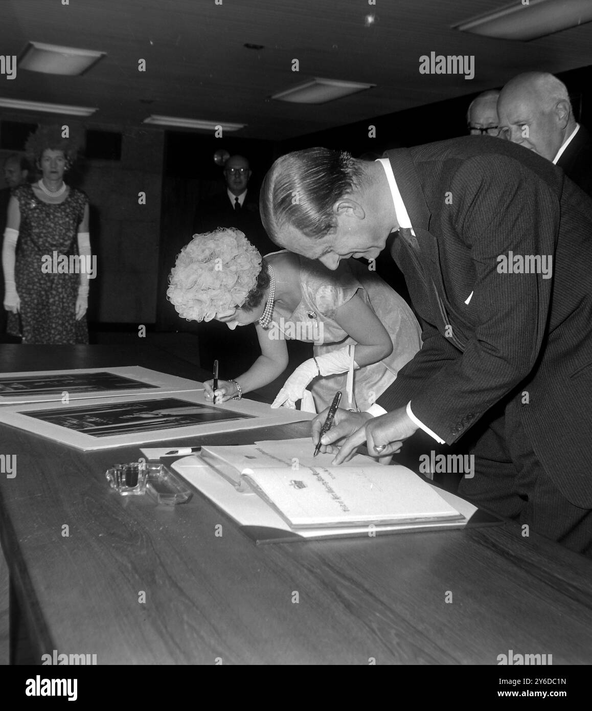 LA REGINA ELISABETTA II E IL PRINCIPE FILIPPO FIRMANO IL LIBRO DEI VISITATORI PRESSO L'IMPERIAL CANCER RESEARCH BUILDING DI LONDRA; 11 GIUGNO 1963 Foto Stock