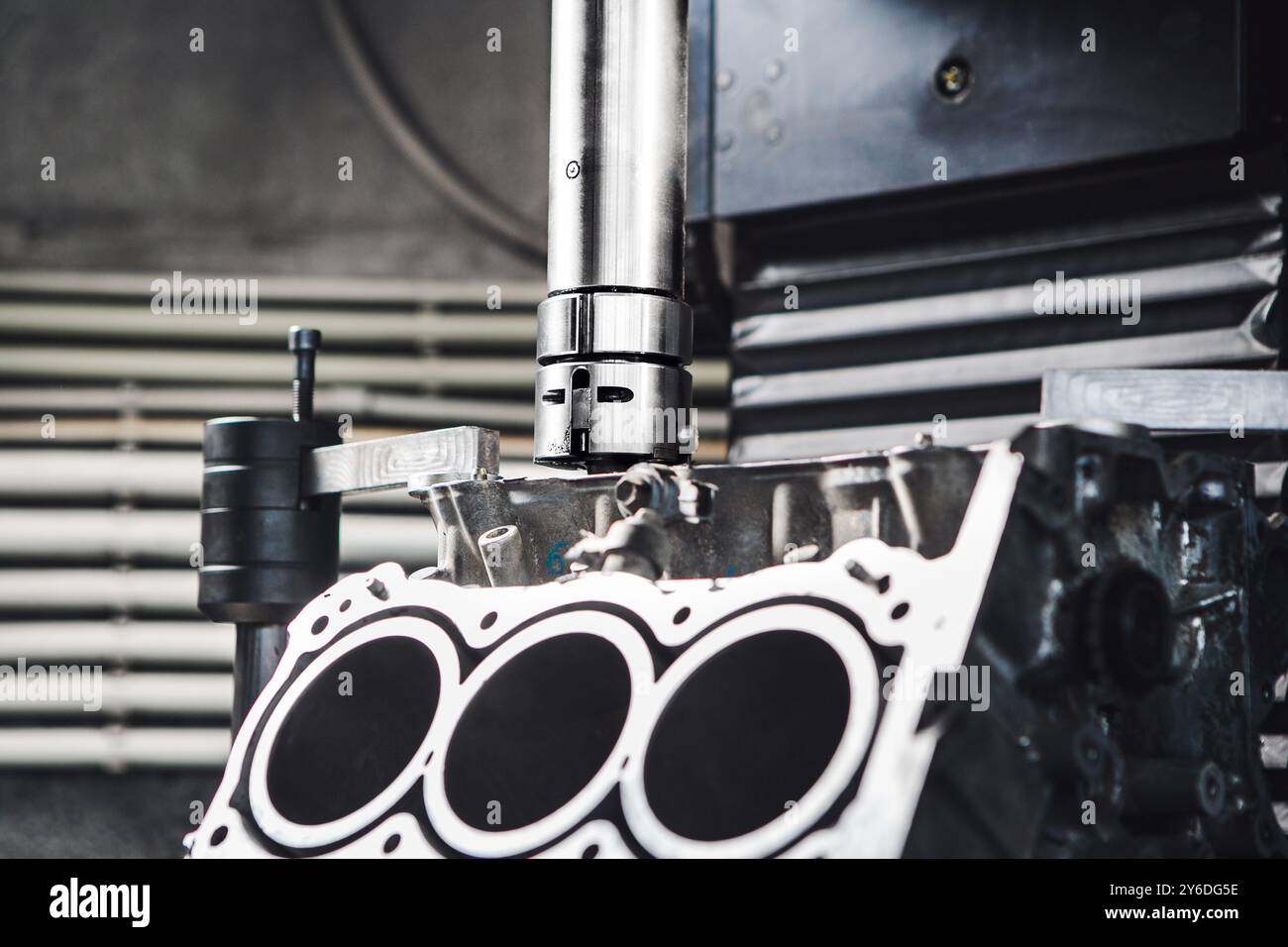 Testata del motore per auto sulla macchina CNC durante la manutenzione del pistone di alesaggio per aumentare la potenza. Foto Stock