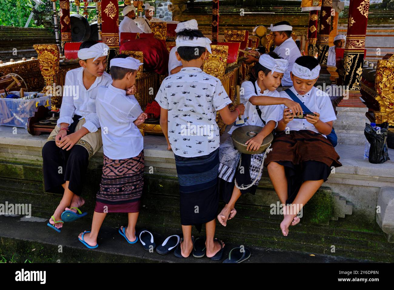 Indonesia, Bali, città di Ubud, tempio pura Samuan Tiga, bambini e telefono cellulare Foto Stock