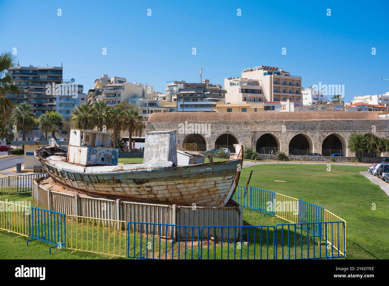 Città vecchia di Heraklion, vista di un peschereccio d'epoca e dei resti di capannoni di navi del XVI secolo - gli Arsenali - nel porto veneziano di Creta Foto Stock