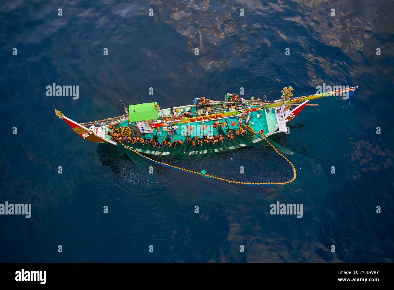 Indonesia, isola di Bali, villaggio di Perancak, barca da pesca riccamente decorata che pesca in mare Foto Stock
