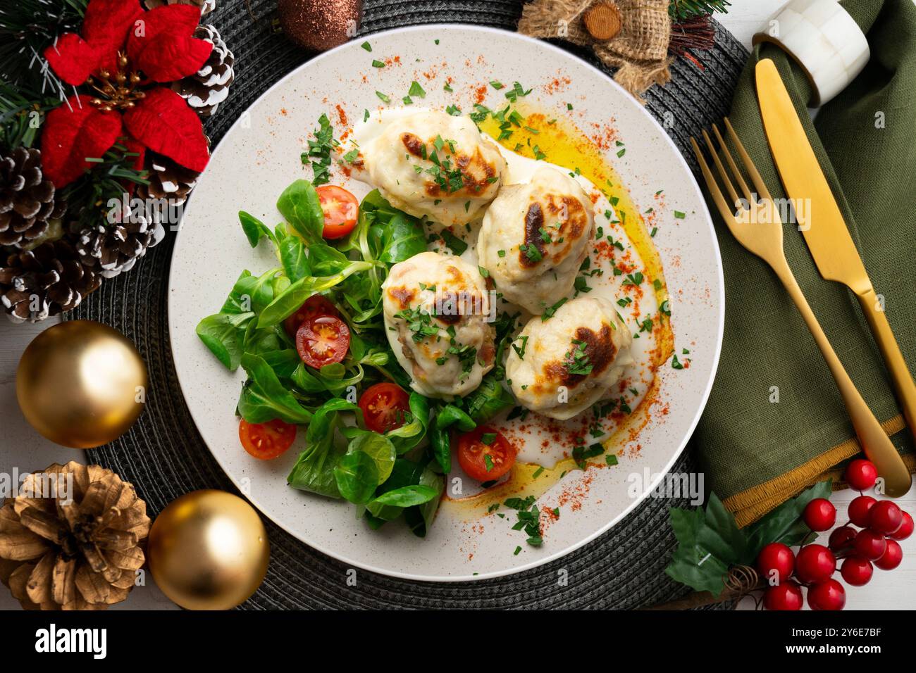 Uova ripiene al gratin con salsa di besciamella. Tavolo con vista dall'alto e decorazioni natalizie. Foto Stock